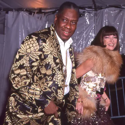 Andre Leon Talley in an intricate gold suit and Anna Wintour alongside him in a fur stole