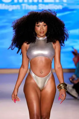 Megan Thee Stallion walks the runway with her hot pink manicure.