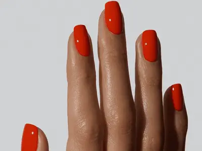 Hand with short bright red nails on a white background