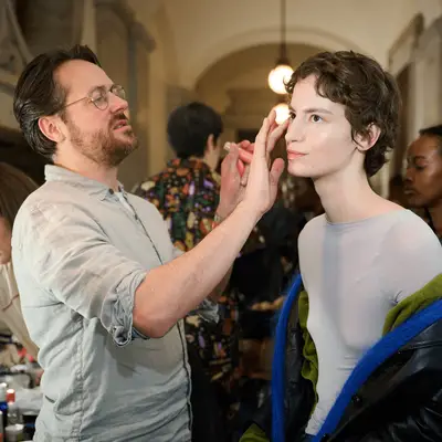 Makeup artist applying products on a model