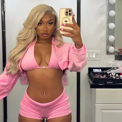 Megan thee stallion with bleach blonde hair and a hot pink outfit