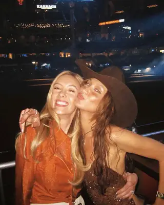 Bella Hadid wearing a copper manicure and hugging a friend