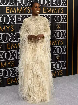 Issa Rae wears an off-white feathered gown and silver jewelry to the January 2024 Emmy Awards