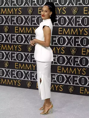 Tracee Ellis Ross wears a white Sportmax skirt set, gold heels, and high ponytail hairstyle to the January 2024 Emmy Awards