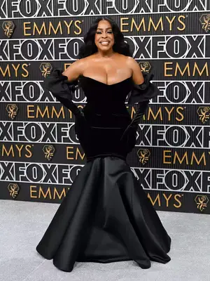 Niecy Nash Betts wears a custom black Greta Constantine gown and opera gloves to the January 2024 Emmy Awards