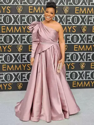 Amber Ruffin wears a mauve one-shoulder gown and updo hairstyle to the 2023 Emmys