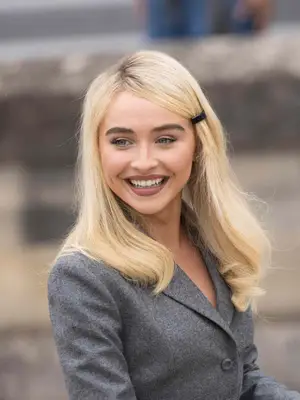 Sabrina Carpenter in her side-parted, bang-less hairstyle.