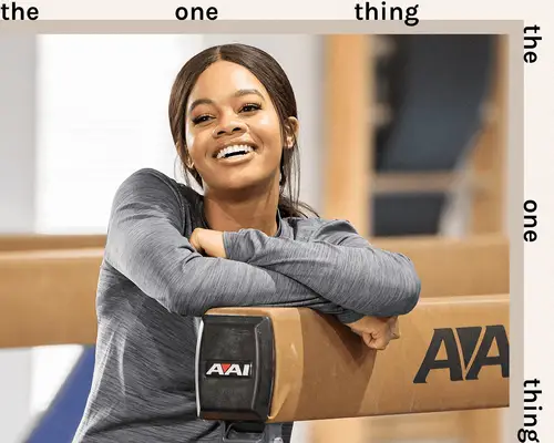 Gabby douglas standing in gymnastic gym smiling