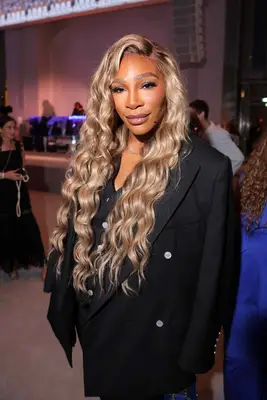 Serena Williams wearing a black suit and blonde hair