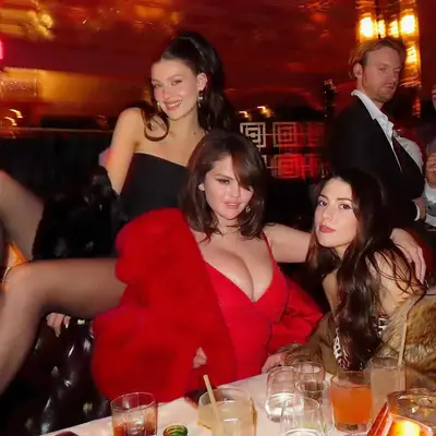Selena Gomez with y2k, millennial side bangs and a red dress posing with Nicola Peltz Beckham