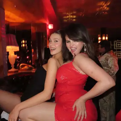 Selena Gomez with y2k, millennial side bangs and a red dress posing with Nicola Peltz Beckham