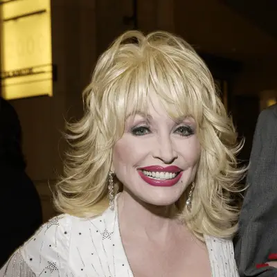 Dolly Parton wears smoky purple eyeshadow and fuschia lipstick