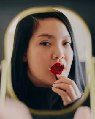 Amanda Nguyen applying lipstick in an e.l.f. campaign