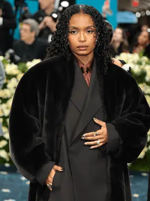 Yara Shahidi at the 2025 Met Gala wearing oversized tailored suit and curly hair