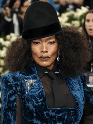 angela bassett wearing burshed-out curls and purple lipstick