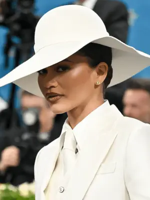 Zendaya wearing all-white outfit with brown liner and gloss and bronzy cheeks