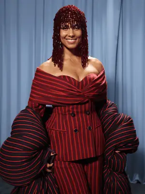 Alicia Keys wearing red headpiece and pinstripe off-the-shouler suit