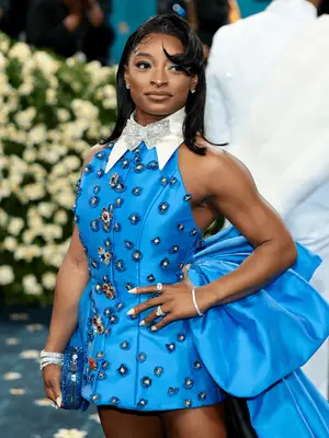 Simone Biles at the 2025 Met Gala wearing blue bedazzled suit gown with flippy hairstyle