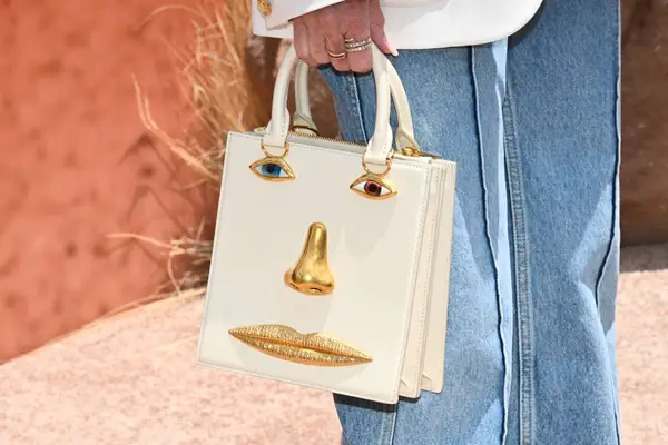 Demi Moore holds her Schiaparelli bag in her square-shaped soft French manicured hand.