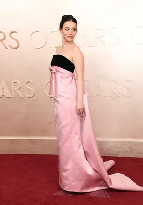 Mikey Madison wears a pink and black gown with bow on the 2025 Oscars red carpet