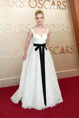 Elle Fanning wears a white gown with black bow to the 2025 Oscars