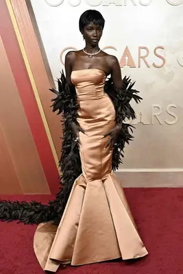 Anok Yai wears a pink gown with black feathered cape to the 2025 Oscars