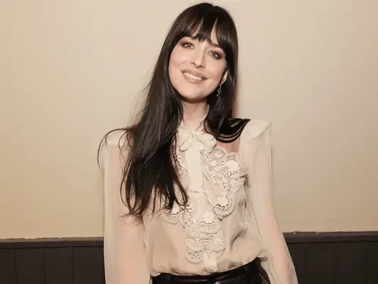 Dakota Johnson in front of a cream wall