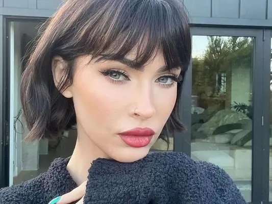 Megan Fox with dark hair and bangs