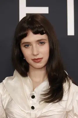 Clairo at the 2025 Grammy Awards with baby bangs and a rosy lip look
