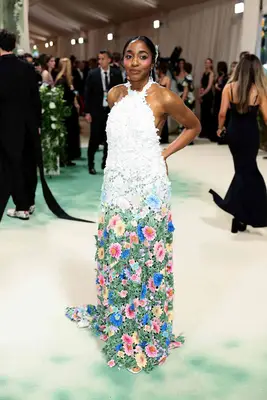 Ayo Edebiri wears a white gown with intricate multicolored floral skirt to the 2024 Met Gala