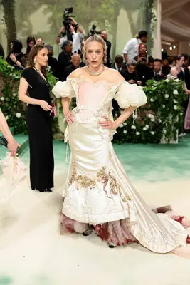Chloe Sevigny wears a cream-colored corseted gown with bows and embroidery to the 2024 Met Gala