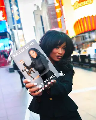 Keke Palmer holding up her book.