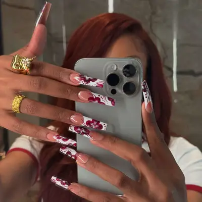 Megan Thee Stallion shows off her hibiscus deep French manicure in a mirror selfie.