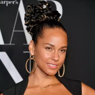alicia keys with high updo and gold details with gold earrings