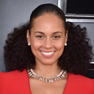 alicia keys with big curly hair, diamond earrings and red dress