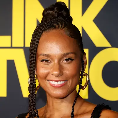 alicia keys with gold heart-shaped hoop earrings, braided updo