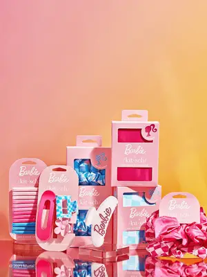 the kitsch x barbie hair accessories on pink ombre background