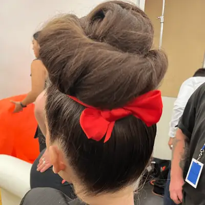 close up of sculptural bun tied with red ribbon