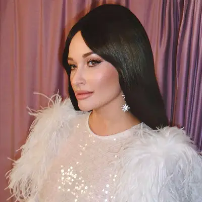 Kacey Musgraves in an all white sequin outfit with Priscilla Presley beehive hairstyle