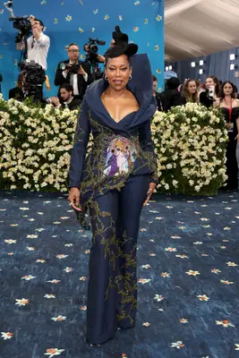 Regina King wears a navy suit with structured neckline, gold detailing, and colorful embroidery to the 2025 Met Gala