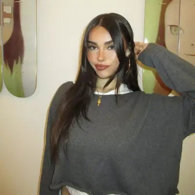 Madison Beer wearing a gray sweater and glossy lipstick