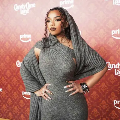 Chloe Bailey on the red carpet for Candy Cane Lane in a hooded gown and mismatched golden nails