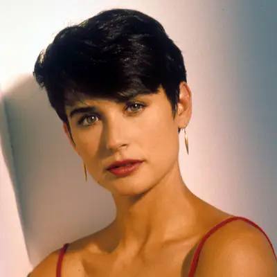Demi Moore with short pixie cut with side-swept bangs and a red lip.