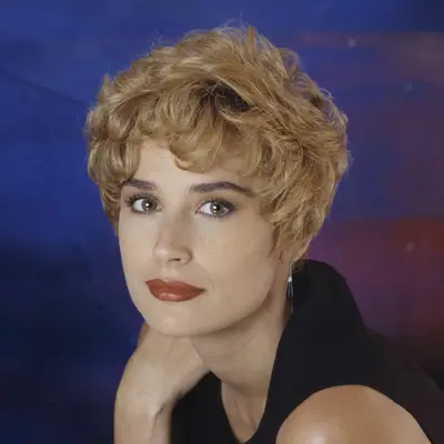 Demi Moore with a blonde pixie cut, dark eyebrows and dark pink lip.