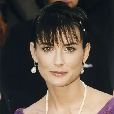 Demi Moore with a pixie cut with bangs, a sparkly eye and glossy lip