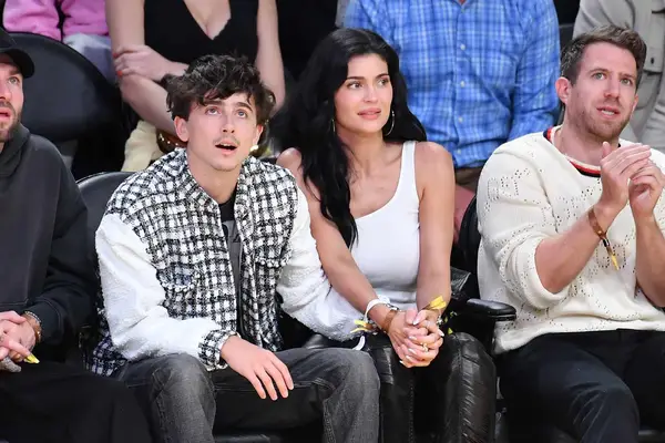 Kylie Jenner and Timothee Chalamet hold hands while sitting courtside at a basketball game.