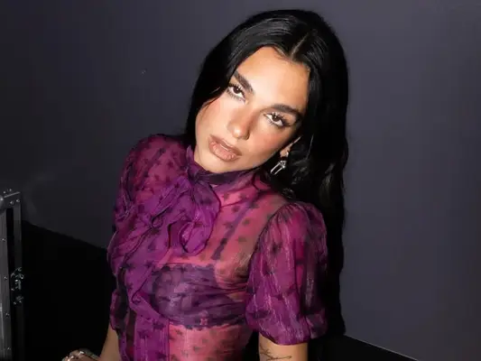 Dua Lipa poses backstage at her concert.