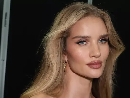 RoÈie Huntington-WHiteley with a blonde blowout hairstyle and glossy lips