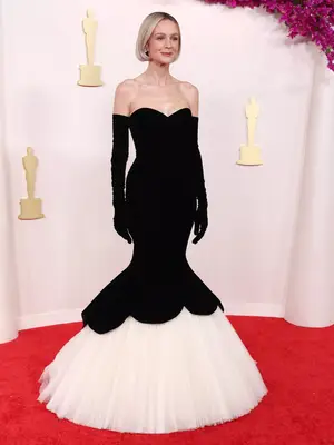 Carey Mulligan wears a black gown with white tulle skirt and opera gloves to the 2024 Oscars