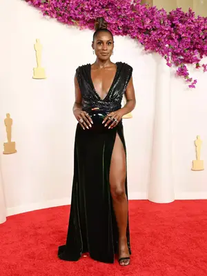 Issa Rae wears a deep green sequined and velvet Ami Paris gown to the 2024 Oscars
